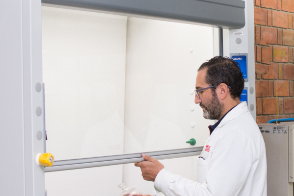 Scientist raising fume hood sash - Universidad Iberoamericana